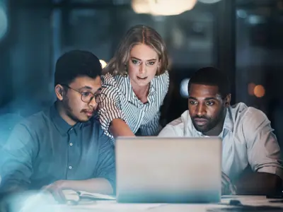 People working together at a laptop looking at the screen