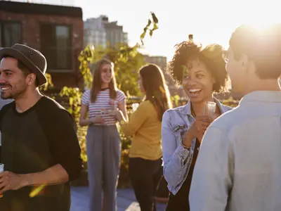 People socializing on an outside terrace at sunset