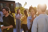 People socializing on an outside terrace at sunset