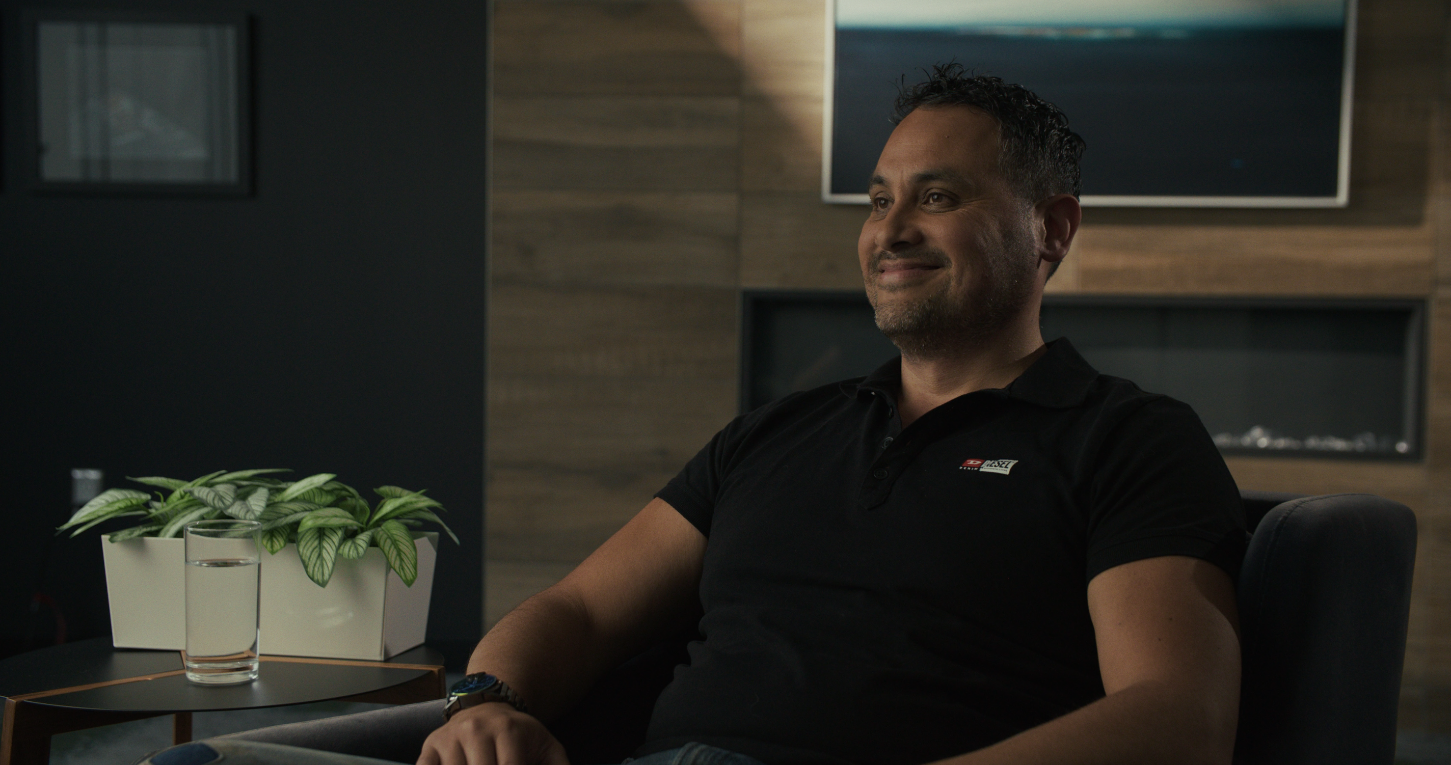 Man smiling, sitting in a chair