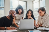 Team working together on a laptop looking at the screen intently
