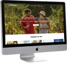 desktop computer with a tourism website on the screen