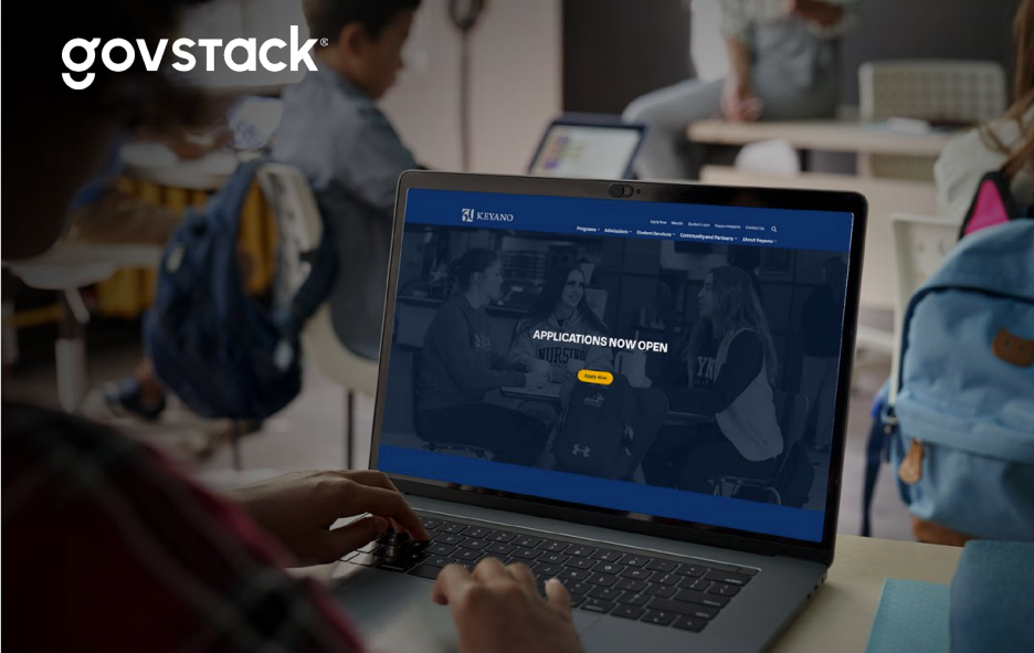 Picture of a student registering at a computer that shows a screen saying Applications Now Open