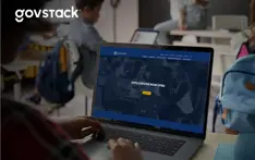 Picture of a student registering at a computer that shows a screen saying Applications Now Open